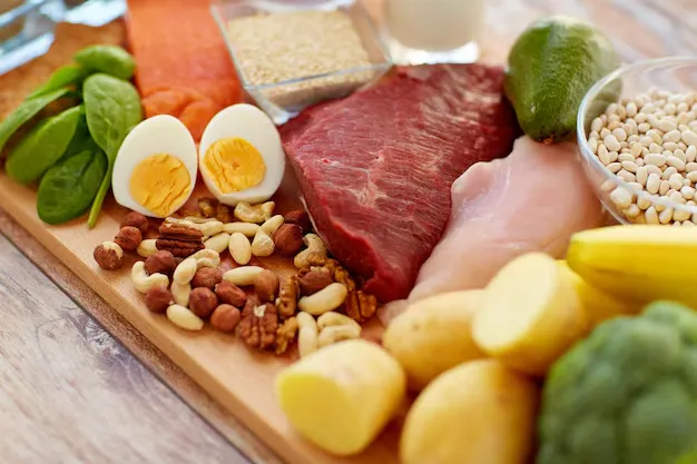 Fresh vegetables and fruits arranged on a wooden table representing balanced nutrition